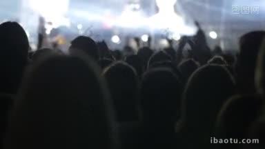 慢动作镜头，人们站在舞台前，观看一个乐队的表演